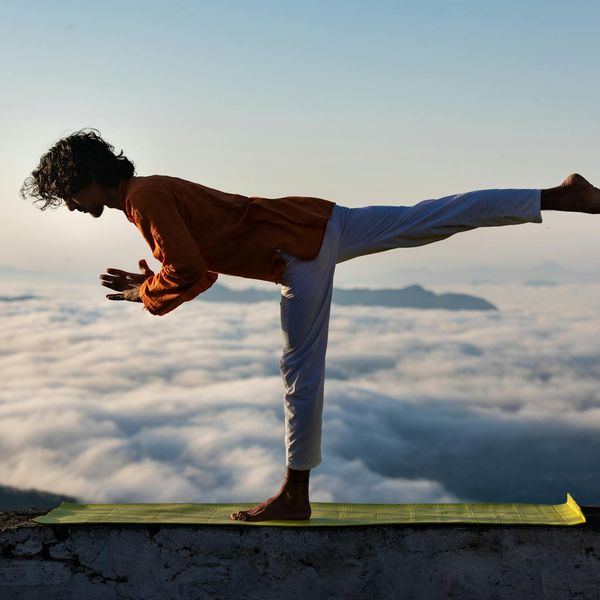 Silhouette of a man stretching against a sunrise, symbolizing daily well-being.